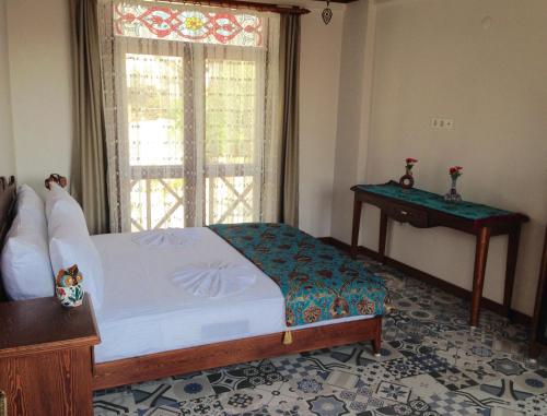 a bedroom with a bed and a window and a table at Hotel Mary's House in Selcuk