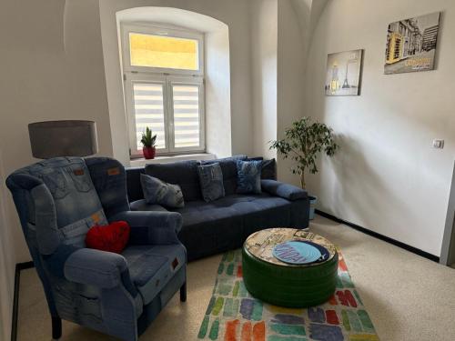 a living room with a blue couch and a table at Apartman I Ubytovani v centru Jihlavy in Jihlava