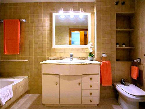a bathroom with a sink and a toilet and a mirror at Harmony Seafront 365 by Can Ventet in Port de Pollensa