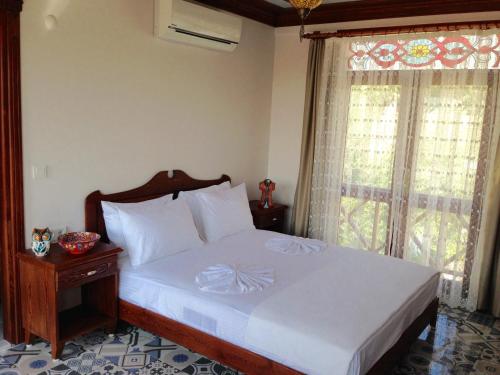 a bedroom with a white bed with a window at Hotel Mary's House in Selcuk