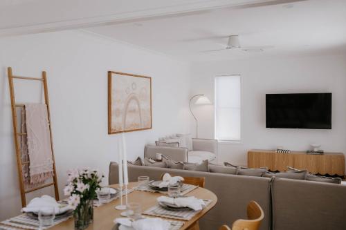 een woonkamer met een bank en een tafel bij Phoenix Jervis Bay Family Coastal Escape in Vincentia