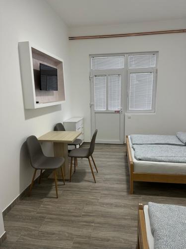 a bedroom with a bed and a table and chairs at Apartman Milanović in Pribojska Banja