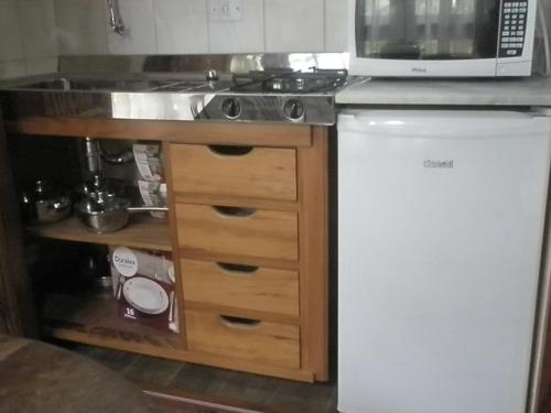 a kitchen with a sink and a microwave at Paraty Villa d`agua Temporada in Paraty