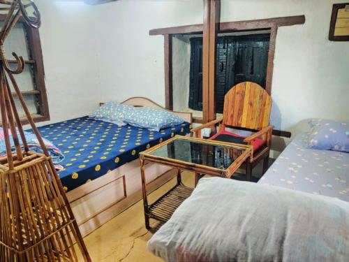 a room with a bed and a chair and a table at Balthali Heritage Inn in Panaoti