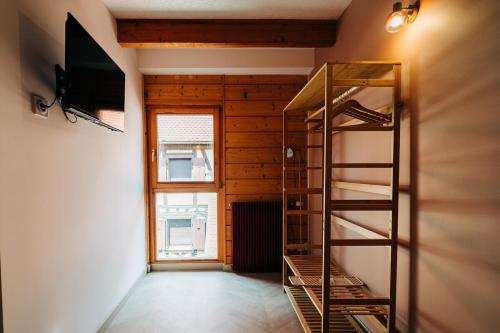 a room with a television and a book shelf at Chai d'oeuvre in Dambach-la-Ville