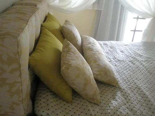 a pile of pillows sitting on a bed at Paraty Villa d`agua Temporada in Paraty