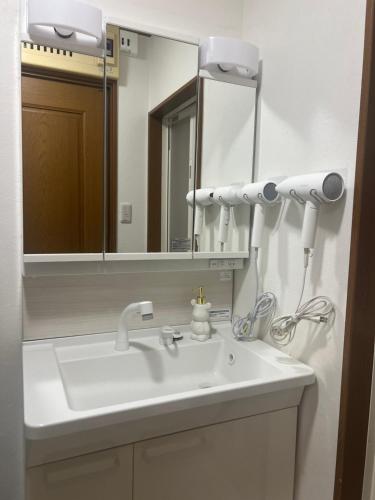 a bathroom with a white sink and a mirror at Yotsuya Lantern - Private 3 stories house for family in Tokyo