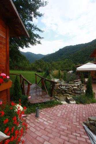 a patio with a wooden bridge and a stone wall at Gasthaus Maria in Borlova