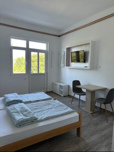 a bedroom with a bed and a table and a desk at Apartman Milanović in Pribojska Banja