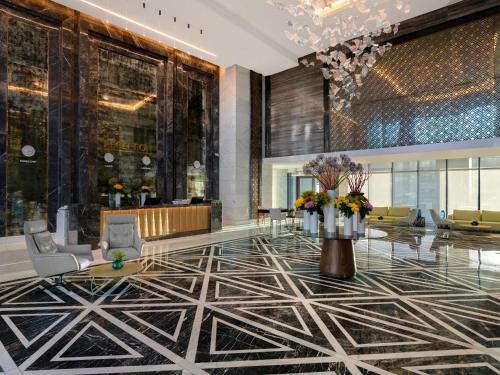 a lobby with a flower arrangement on the floor at Rixos Premium Alamein in El Alamein