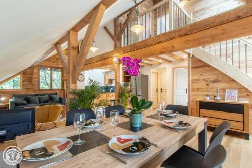 a dining room and living room with a table and chairs at Gite dans corps de ferme in Groisy