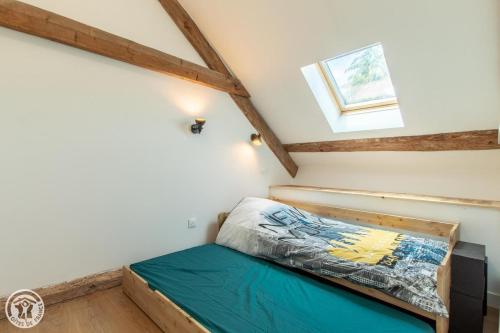 a bed in a small room with a window at Gite dans corps de ferme in Groisy