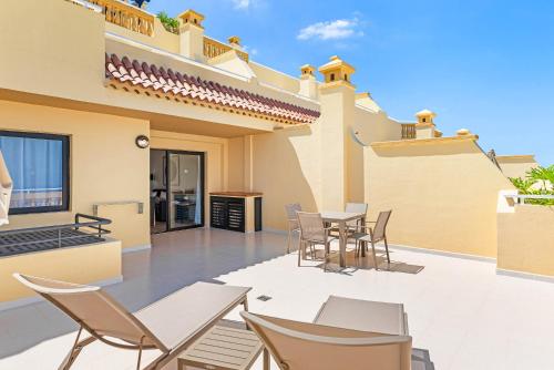 a patio of a house with chairs and a table at Ramada Residences by Wyndham Costa Adeje in Adeje