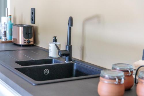 Un fregadero de cocina con un grifo sobre una encimera en Demerzicht, en Aarschot