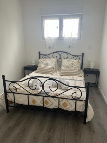 un letto in una camera da letto con due finestre di le relais des étangs a Mareuil-Caubert
