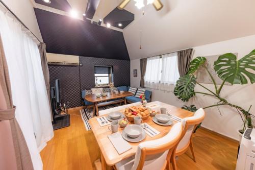 a dining room and living room with a table and chairs at NOT A HOME亀有 駅徒歩5分 無料駐車場 ディズニーまで車22分 羽田空行バス直通 90m2 in Tokyo