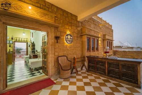 a room with a stone wall and a checkerboard floor at Wild Heritage Desert Camp in Jaisalmer