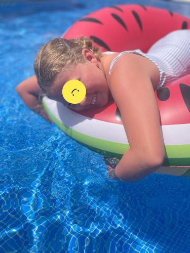 a young child laying on a raft in a pool at Nerja Rio marinas Playa, Garden with Pool in Nerja