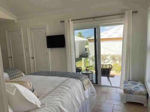 a bedroom with a bed and a sliding glass door at Ocean Villa SeaScape in Treasure Cay
