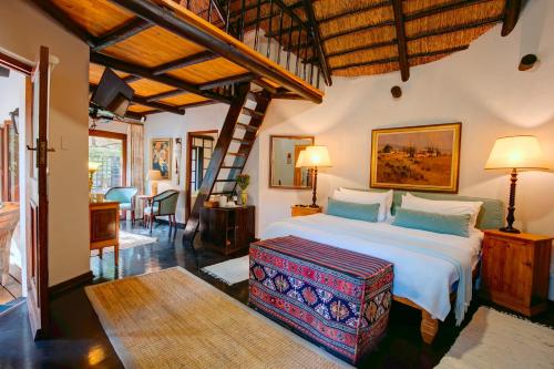 a bedroom with a large bed with a wooden ceiling at Moontide Riverside Lodge in Wilderness