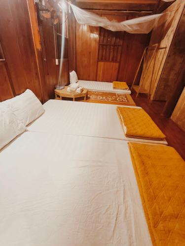 a group of three beds in a room at Nùng An homestay in Quảng Uyên