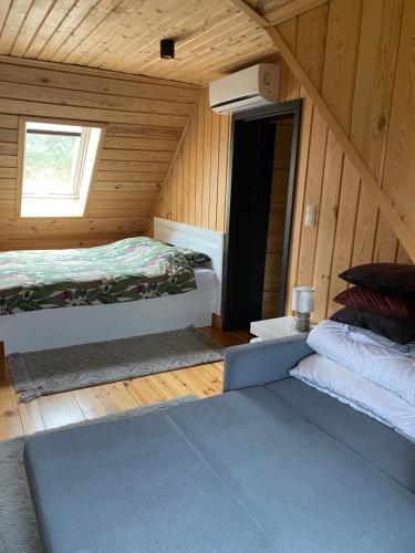 a room with two beds in a wooden cabin at Agroturystyka Podlasie dom nad stawem in Dobrzyniewo Duże