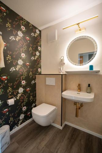 a bathroom with a sink and a toilet and a mirror at Altdeutscher Hof Beckord in Gütersloh