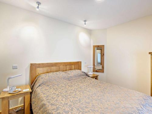 a bedroom with a bed and two tables and a mirror at 1 Bed in Ross-on-Wye 49910 in Walford