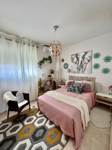 Un dormitorio con una cama, una silla y una lámpara de araña. en Sevilla tu casa, en Espartinas