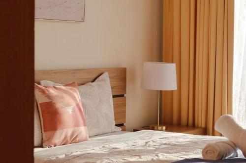 a bedroom with a bed with pillows and a lamp at Morden Sandy Bay Home The Ultimate Base in Hobar in Sandy Bay