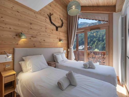 zwei Betten in einem Zimmer mit Fenster in der Unterkunft Bel appartement moderne, proche des pistes, à Méribel - FR-1-565-98 in Les Allues