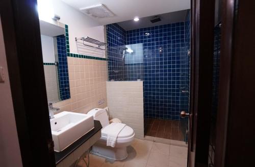 ein Badezimmer mit Toilette, Waschbecken und Dusche in der Unterkunft Baan Huenphen Boutique Hotel in Chiang Mai
