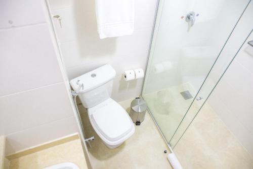 a bathroom with a toilet and a glass shower at House Inn Hotel - Anashopping in Anápolis