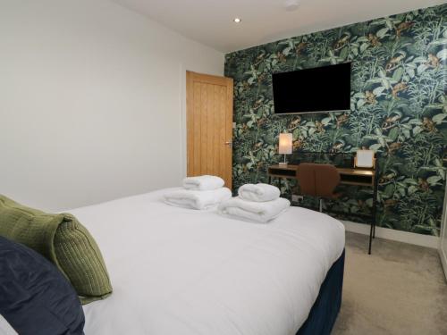 ein Hotelzimmer mit einem Bett mit Handtüchern darauf in der Unterkunft Highfield Cottage in Windermere