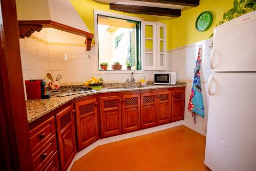 a kitchen with wooden cabinets and a white refrigerator at Casa Rural Virgen del Rosario in San Juan de la Rambla