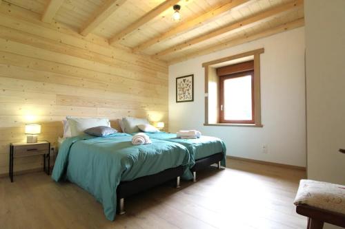 a bedroom with a large bed with a wooden ceiling at La Clé des Champs à Bussang - Gîte tout confort dans les Hautes Vosges in Bussang