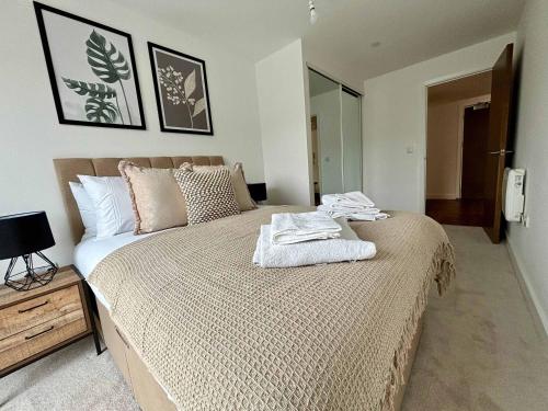 een slaapkamer met een bed met twee handdoeken erop bij Luxury 2 bed Apartment Bracknell in Bracknell