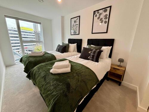 a bedroom with two beds and a window at Luxury 2 bed Apartment Bracknell in Bracknell