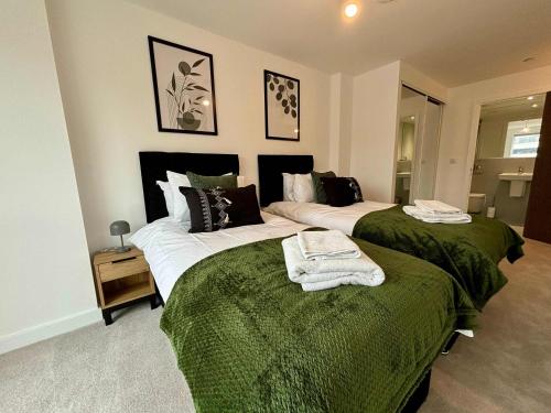 twee bedden in een kamer met groen en wit bij Luxury 2 bed Apartment Bracknell in Bracknell