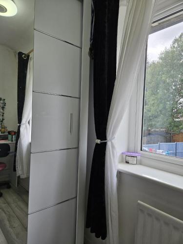 a bedroom with a window and a white dresser at Family Home 1 in Carshalton