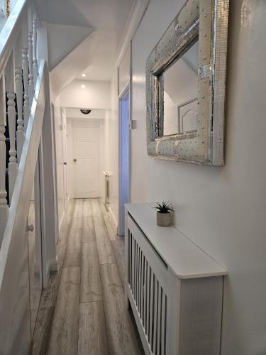 a hallway with a mirror on the wall at Family Home 1 in Carshalton