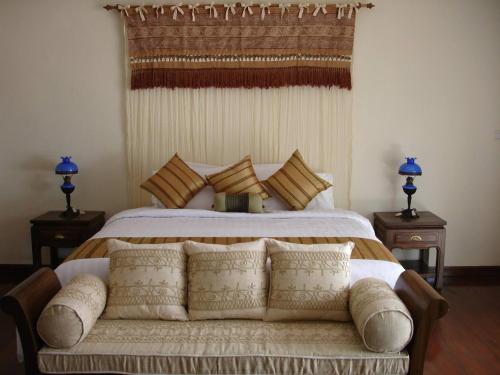 a bedroom with a large bed with pillows at Nakara Samui-Deluxe beach front in Ban Thong Phlu