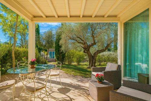 a screened in porch with a glass table and chairs at Hotiday Lodge Cecina in Cecina