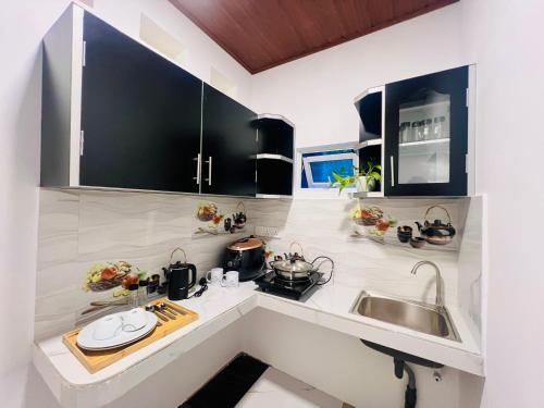 a kitchen with black cabinets and a sink at Villa Eco Stay in Tangalle
