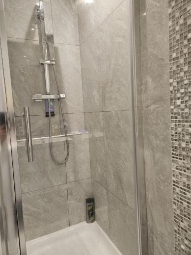 a bathroom with a shower with a glass door at Family Home 1 in Carshalton