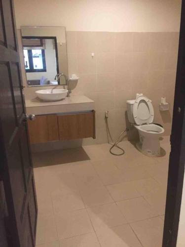 a bathroom with a toilet and a sink and a mirror at Nakara Samui S4 Two Bedrooms Apt in Ban Thong Phlu