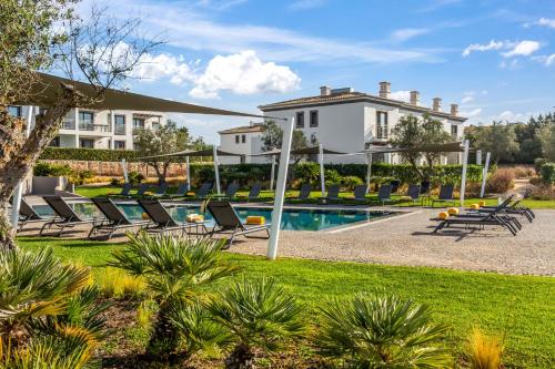 a villa with a swimming pool and lawn at Quinta do Algarvio Village in Carvoeiro