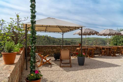 a patio with tables and umbrellas and chairs at TRUFFLE'N'BED in San Giovanni dʼAsso