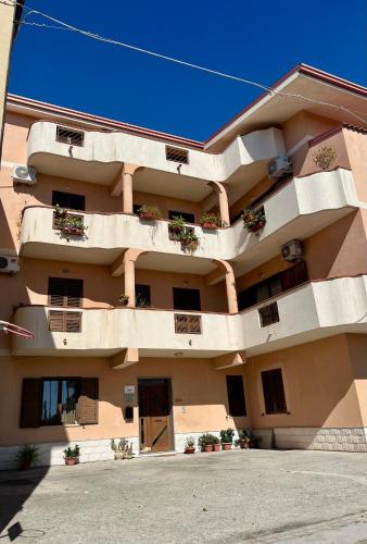 a large apartment building with potted plants on it at Kalon Eidos, il magico posto della Calabria Jonica in Condofuri Marina