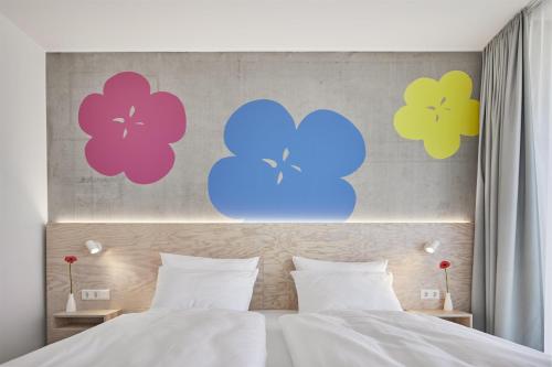 ein Schlafzimmer mit bunten Blumen an der Wand in der Unterkunft Flowers Hotel Essen in Essen